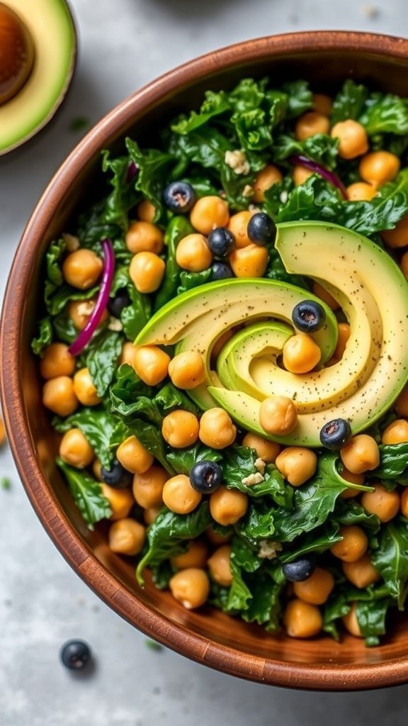 A bowl of massaged kale salad topped with avocado slices and chickpeas.